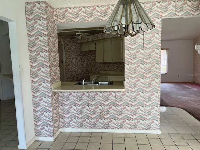 8130 Shalom Dr, Spring Hill, FL 34606 - kitchen featuring a sink, light countertops, a chandelier, wallpapered walls, and light tile patterned floors