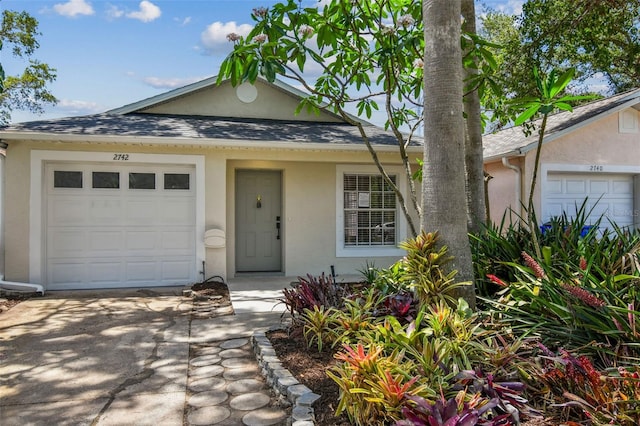 2742 Wilson Ct, Palm Harbor, FL 34684 - view of front of house featuring stucco siding, concrete driveway, an attached garage, and a shingled roof