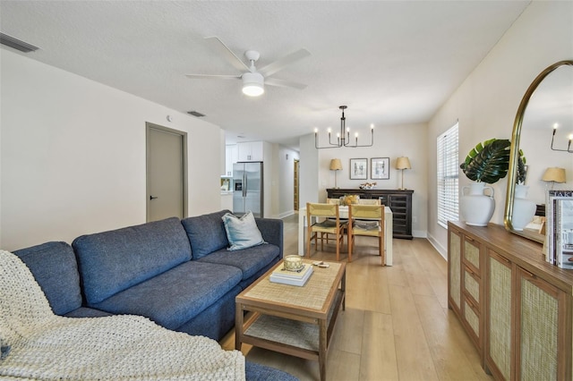 2742 Wilson Ct, Palm Harbor, FL 34684 - living area featuring a chandelier, light wood-type flooring, a ceiling fan, and baseboards