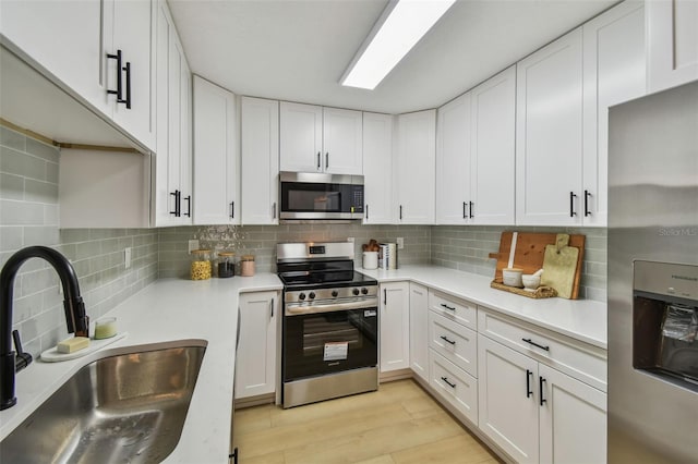 2742 Wilson Ct, Palm Harbor, FL 34684 - kitchen with appliances with stainless steel finishes, a sink, tasteful backsplash, and white cabinetry