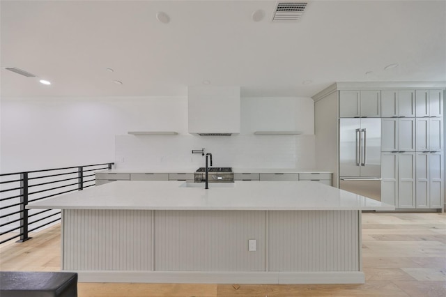 1801 N Morgan St Unit 5, Tampa, FL 33602 - kitchen with stainless steel built in refrigerator, light countertops, tasteful backsplash, light wood finished floors, and recessed lighting
