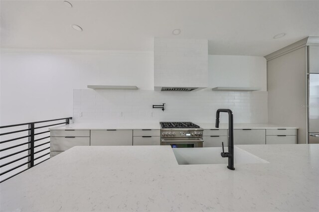1801 N Morgan St Unit 5, Tampa, FL 33602 - kitchen with premium appliances, a sink, backsplash, light stone counters, and exhaust hood