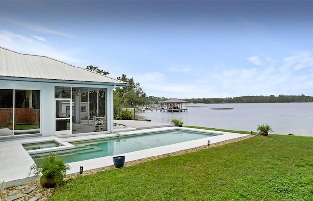 8701 Lake Calm Ln, Odessa, FL 33556 - view of swimming pool featuring a yard, a water view, a sunroom, a pool with connected hot tub, and a patio area