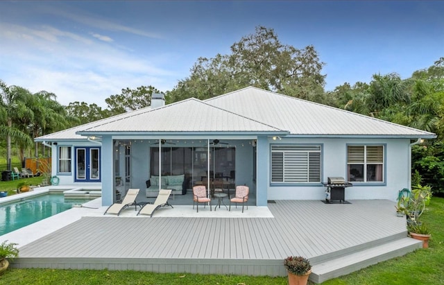 8701 Lake Calm Ln, Odessa, FL 33556 - back of house with a deck, ceiling fan, an outdoor pool, a chimney, and stucco siding