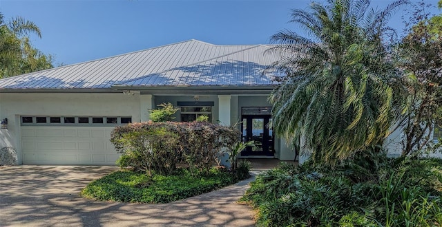 8701 Lake Calm Ln, Odessa, FL 33556 - view of front facade with stucco siding, concrete driveway, a garage, and metal roof
