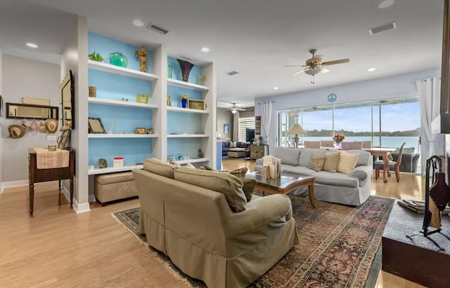 8701 Lake Calm Ln, Odessa, FL 33556 - living area featuring ceiling fan, light wood finished floors, built in shelves, baseboards, and recessed lighting