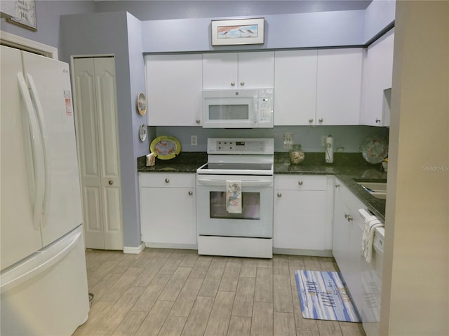 834 Tremont Greens Ln Unit 137, Sun City Center, FL 33573 - kitchen featuring white appliances, white cabinetry, dark countertops, and light wood finished floors