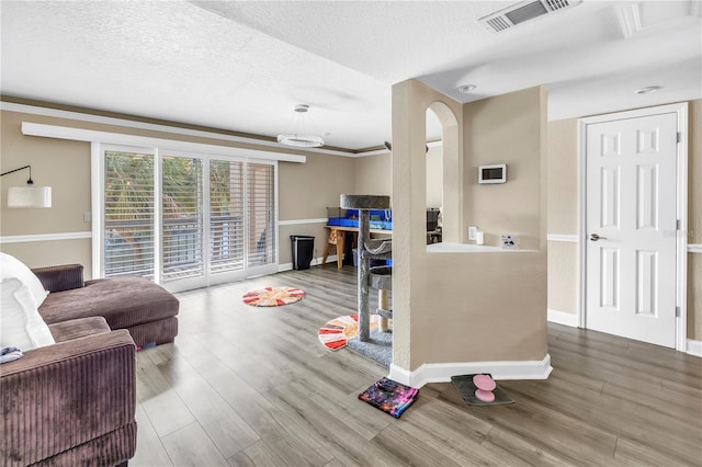 6309 Newtown Cir Unit 9B2, Tampa, FL 33615 - living area with a textured ceiling, wood finished floors, baseboards, arched walkways, and crown molding