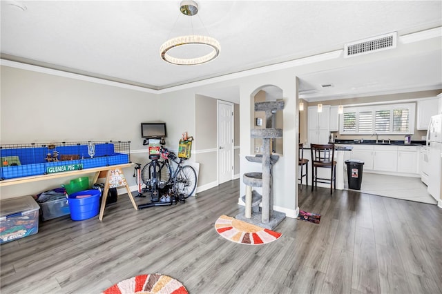 6309 Newtown Cir Unit 9B2, Tampa, FL 33615 - exercise room with crown molding, wood finished floors, arched walkways, a sink, and baseboards