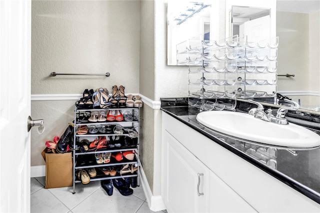 6309 Newtown Cir Unit 9B2, Tampa, FL 33615 - bathroom featuring vanity, tile patterned flooring, a textured wall, and baseboards