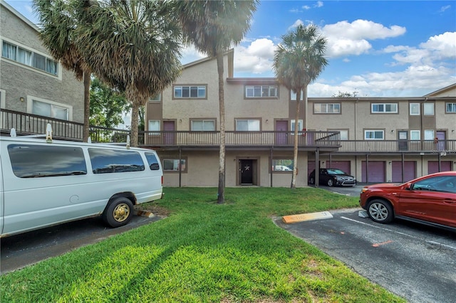 6309 Newtown Cir Unit 9B2, Tampa, FL 33615 - view of front of property with uncovered parking, a front lawn, and stucco siding