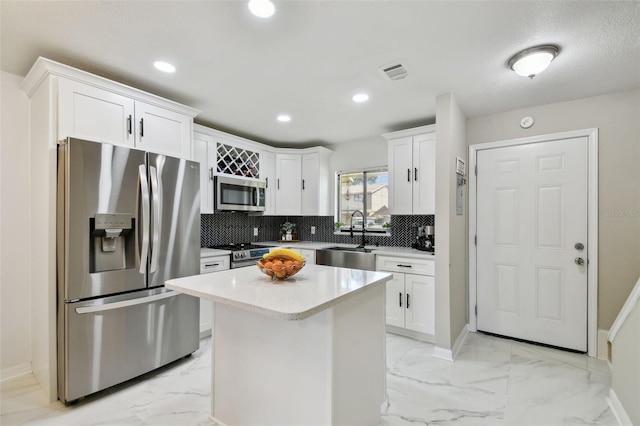 4017 Cedar Limb Ct, Tampa, FL 33614 - kitchen featuring stainless steel appliances, a sink, light marble finish floors, white cabinetry, and decorative backsplash