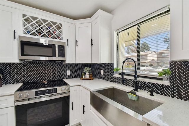 4017 Cedar Limb Ct, Tampa, FL 33614 - kitchen featuring stainless steel appliances, a sink, tasteful backsplash, white cabinets, and light stone countertops