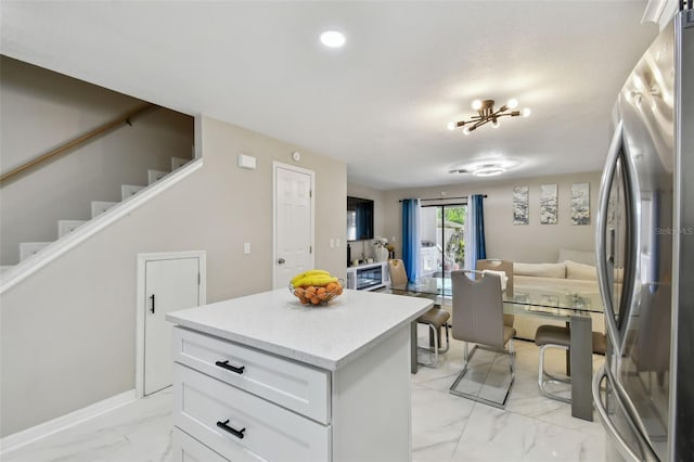 4017 Cedar Limb Ct, Tampa, FL 33614 - kitchen featuring freestanding refrigerator, light marble finish flooring, open floor plan, light countertops, and white cabinets