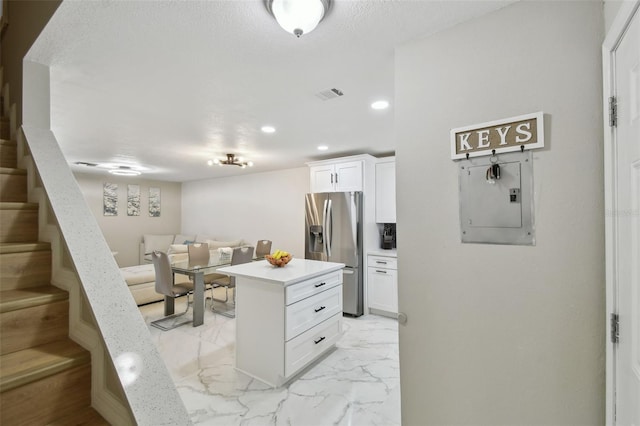 4017 Cedar Limb Ct, Tampa, FL 33614 - kitchen with stainless steel fridge with ice dispenser, electric panel, light countertops, white cabinetry, and light marble finish flooring