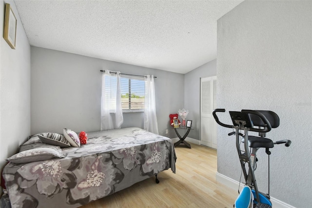 4017 Cedar Limb Ct, Tampa, FL 33614 - bedroom with wood finished floors, a textured ceiling, a closet, vaulted ceiling, and baseboards