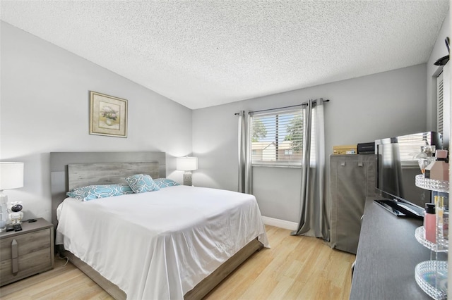 4017 Cedar Limb Ct, Tampa, FL 33614 - bedroom featuring light wood-type flooring, a textured ceiling, and vaulted ceiling