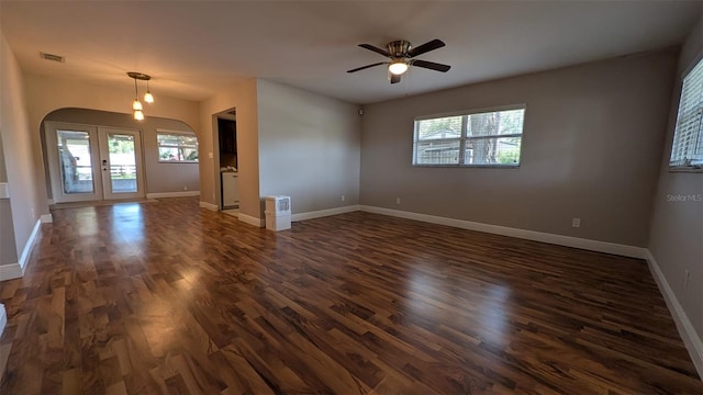 4021 19th St N, Saint Petersburg, FL 33714 - empty room featuring arched walkways, healthy amount of natural light, a ceiling fan, and dark wood-style floors