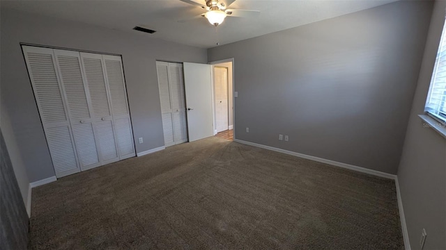 4021 19th St N, Saint Petersburg, FL 33714 - unfurnished bedroom featuring two closets, carpet floors, baseboards, and a ceiling fan