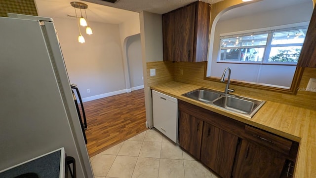 4021 19th St N, Saint Petersburg, FL 33714 - kitchen with dishwasher, arched walkways, a sink, and freestanding refrigerator
