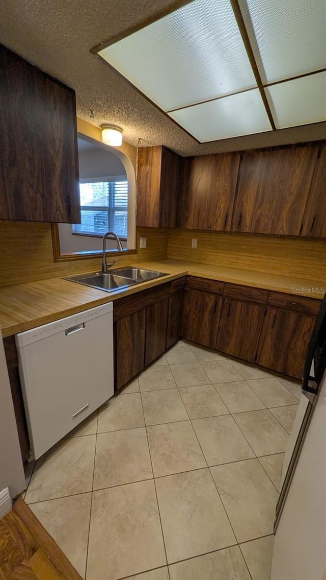 4021 19th St N, Saint Petersburg, FL 33714 - kitchen featuring white dishwasher, a sink, wood counters, and light tile patterned flooring