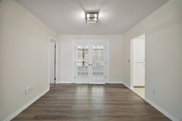 9755 SE 176th St, Summerfield, FL 34491 - unfurnished room with french doors, wood finished floors, baseboards, and a textured ceiling