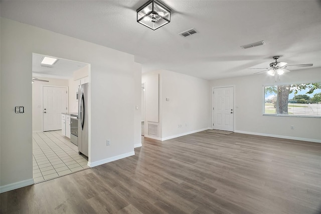 9755 SE 176th St, Summerfield, FL 34491 - unfurnished living room with ceiling fan, wood finished floors, and baseboards