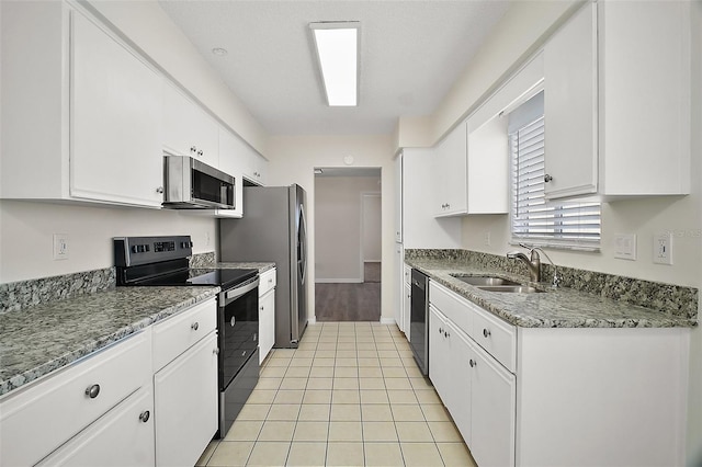 9755 SE 176th St, Summerfield, FL 34491 - kitchen with stainless steel appliances, a sink, white cabinetry, light stone countertops, and light tile patterned flooring
