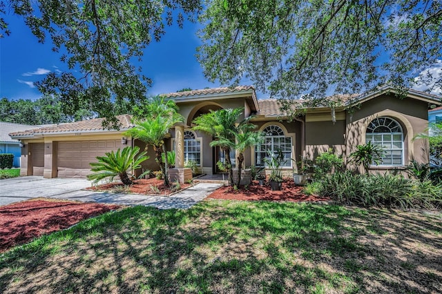 1516 E Lake Woodlands Pkwy, Oldsmar, FL 34677 - mediterranean / spanish-style house with stucco siding, asphalt driveway, a garage, a tile roof, and a front lawn