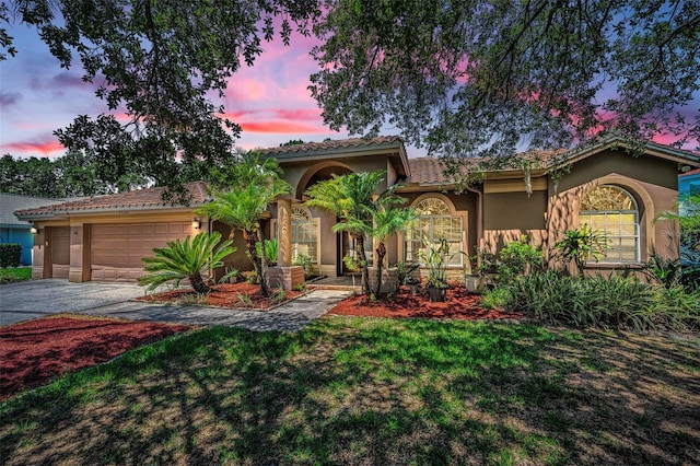 1516 E Lake Woodlands Pkwy, Oldsmar, FL 34677 - mediterranean / spanish-style home with stucco siding, asphalt driveway, an attached garage, a lawn, and a tiled roof