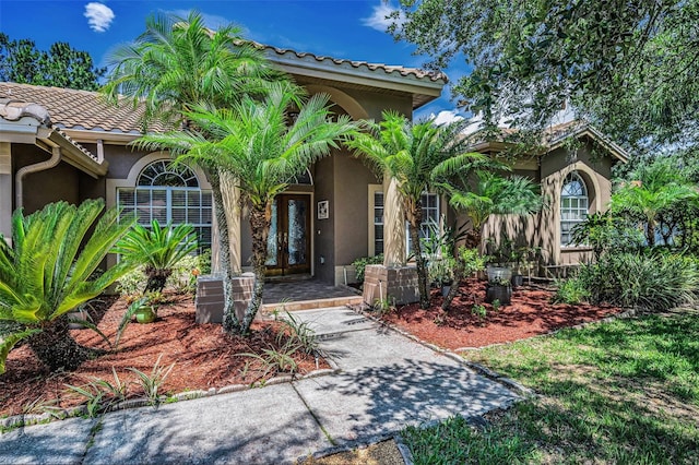 1516 E Lake Woodlands Pkwy, Oldsmar, FL 34677 - property entrance featuring stucco siding, french doors, and a tile roof