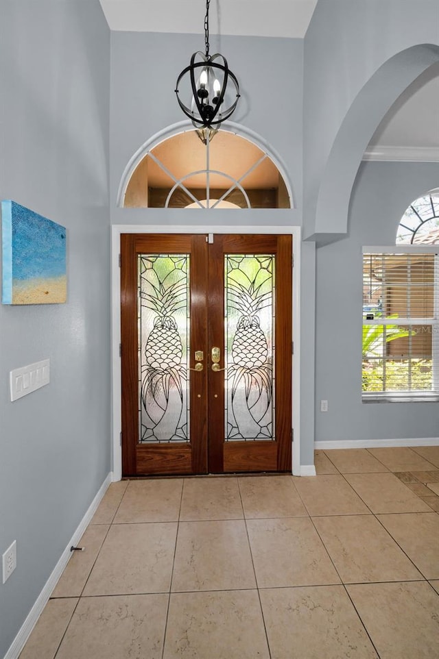 1516 E Lake Woodlands Pkwy, Oldsmar, FL 34677 - foyer entrance featuring a chandelier, french doors, light tile patterned floors, and baseboards
