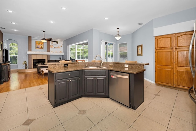 1516 E Lake Woodlands Pkwy, Oldsmar, FL 34677 - kitchen featuring stainless steel dishwasher, a sink, a tile fireplace, ceiling fan, and recessed lighting