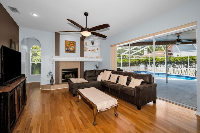 1516 E Lake Woodlands Pkwy, Oldsmar, FL 34677 - living room with a ceiling fan, a sunroom, wood finished floors, a fireplace, and recessed lighting