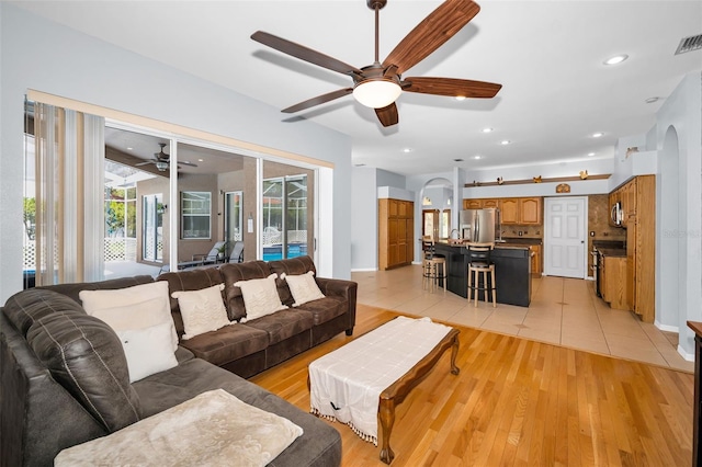 1516 E Lake Woodlands Pkwy, Oldsmar, FL 34677 - living area featuring arched walkways, a ceiling fan, light wood-style floors, and recessed lighting
