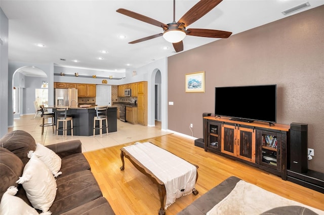 1516 E Lake Woodlands Pkwy, Oldsmar, FL 34677 - living area with arched walkways, a ceiling fan, recessed lighting, light wood-style floors, and baseboards