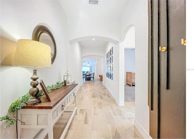 12010 Jackson Landing Pl, Tampa, FL 33624 - corridor featuring arched walkways, light wood-style floors, and baseboards