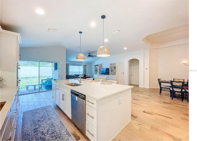 12010 Jackson Landing Pl, Tampa, FL 33624 - kitchen featuring stainless steel appliances, arched walkways, an island with sink, open floor plan, and white cabinetry