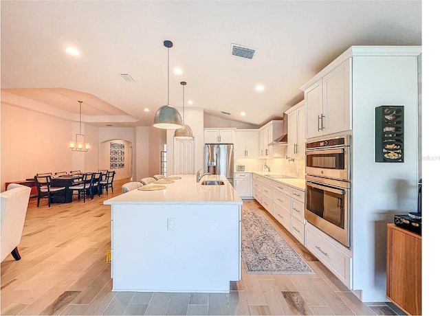 12010 Jackson Landing Pl, Tampa, FL 33624 - kitchen with stainless steel appliances, a sink, lofted ceiling, light countertops, and recessed lighting