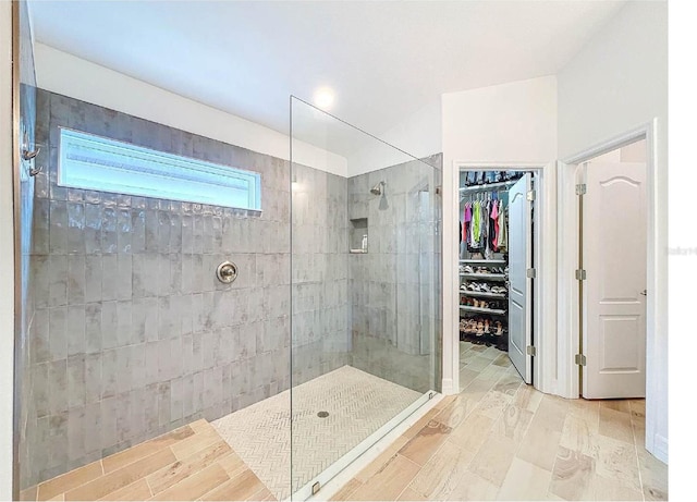 12010 Jackson Landing Pl, Tampa, FL 33624 - bathroom with walk in shower, a walk in closet, and wood finished floors