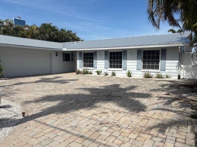12055 4th St E, Treasure Island, FL 33706 - view of front of house with an attached garage and metal roof