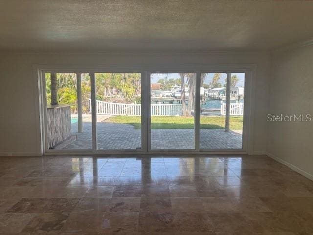 12055 4th St E, Treasure Island, FL 33706 - doorway to outside featuring baseboards, a water view, and a textured ceiling