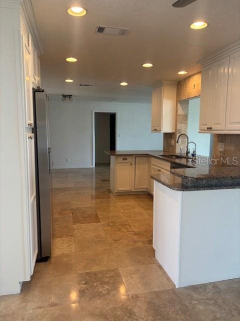 12055 4th St E, Treasure Island, FL 33706 - kitchen featuring a peninsula, a sink, freestanding refrigerator, backsplash, and recessed lighting