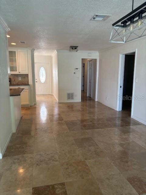 12055 4th St E, Treasure Island, FL 33706 - unfurnished living room with baseboards and a textured ceiling