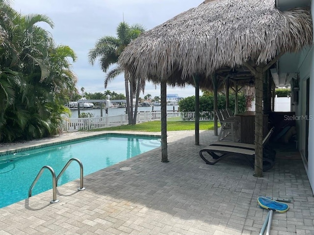 12055 4th St E, Treasure Island, FL 33706 - view of swimming pool featuring a water view, a fenced backyard, and a patio