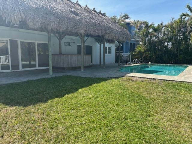 12055 4th St E, Treasure Island, FL 33706 - swimming pool featuring a patio area and a lawn