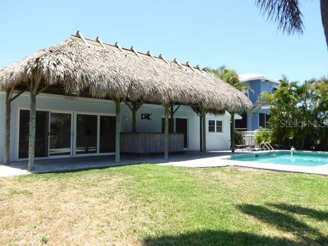 12055 4th St E, Treasure Island, FL 33706 - back of house featuring a patio area, a yard, and an outdoor pool