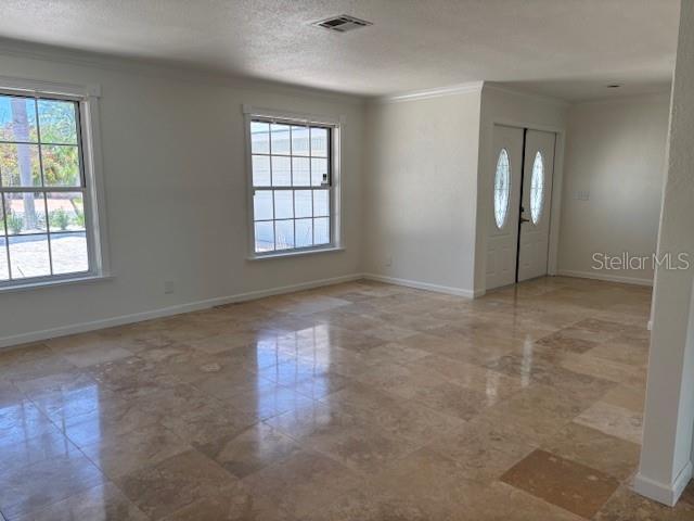 12055 4th St E, Treasure Island, FL 33706 - unfurnished room with crown molding and a textured ceiling