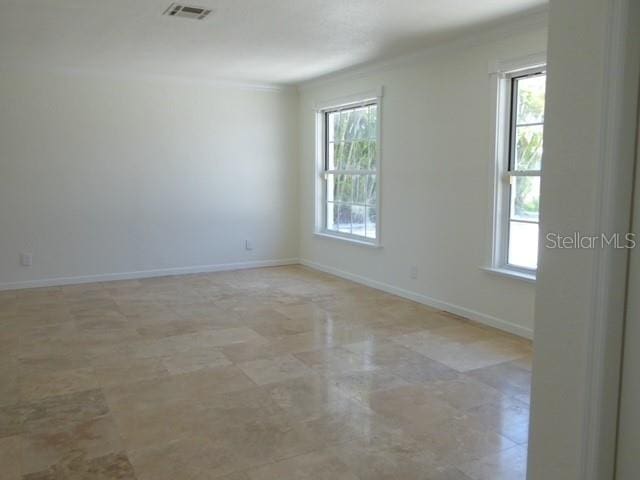 12055 4th St E, Treasure Island, FL 33706 - empty room with plenty of natural light and crown molding