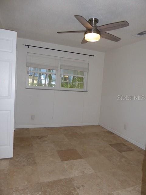 12055 4th St E, Treasure Island, FL 33706 - spare room featuring a ceiling fan and baseboards